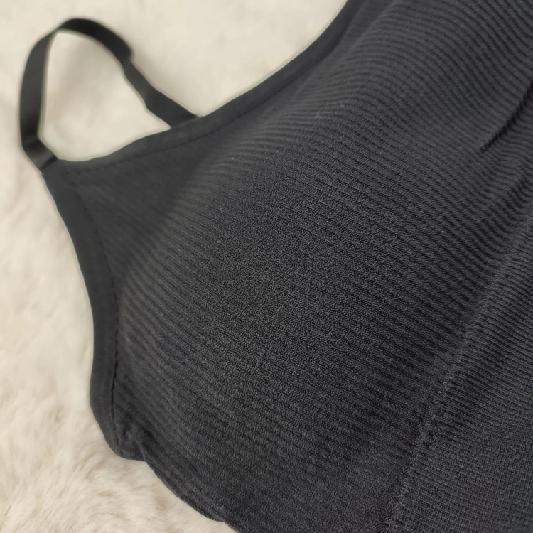 Zbliżenie na miseczkę czarnego biustonosza prążkowanego z widoczną teksturą materiału.