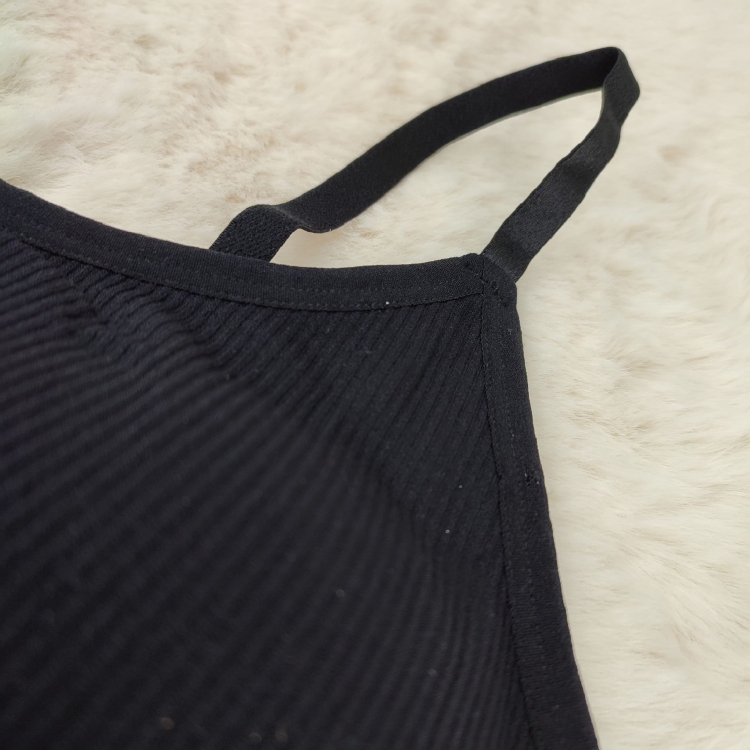 Detal łączenia cienkiego ramiączka z miseczką w biustonoszu prążkowanym.