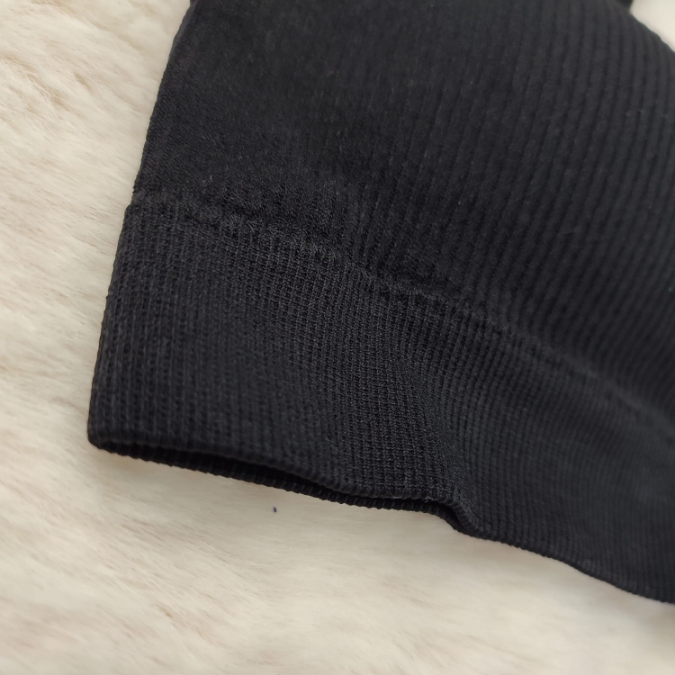 Szeroki, elastyczny ściągacz dolny w czarnym biustonoszu prążkowanym.