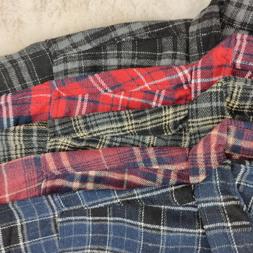 Zbliżenie na kołnierzyki i wzory kolorystyczne koszul flanelowych w kratę