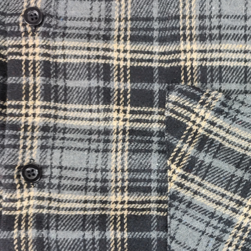 Struktura materiału i wzór szarej koszuli flanelowej w kratę z widocznym guzikiem.